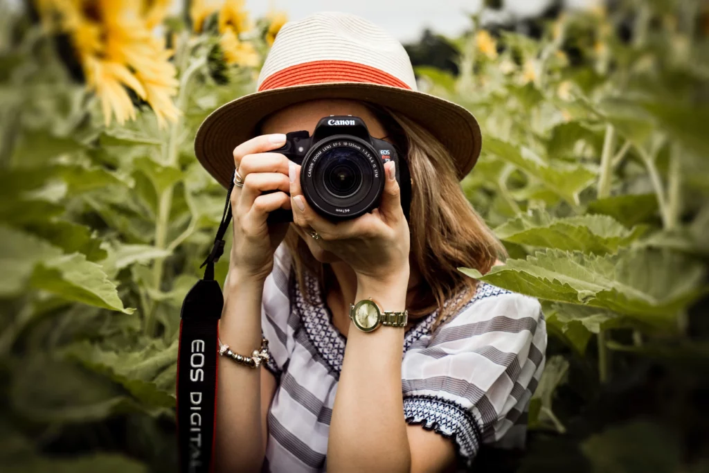 Woman holding a camera, looking through the viewfinder